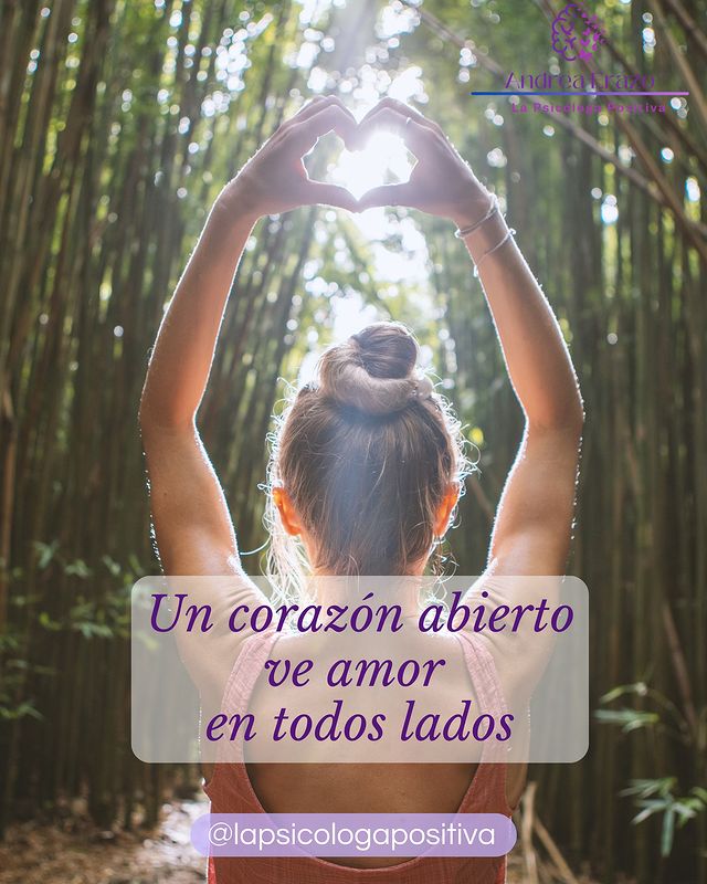 Mujer de espaldas formando un corazon con las manos de frente hacia un bosque, junto con la leyenda 'Un corazón abierto ve amor en todos lados'