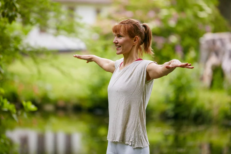 mujer con los brazos abiertos, sonriendo