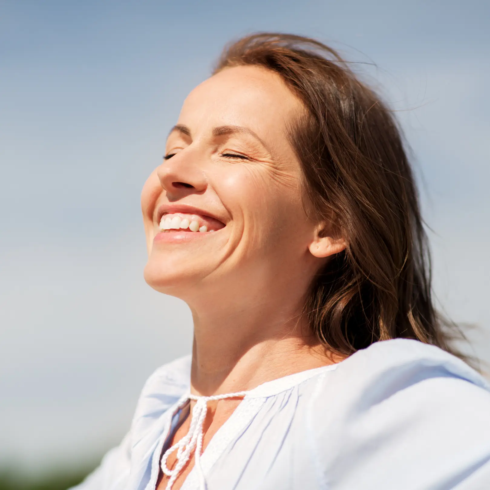 Mujer con los ojos cerrados feliz disfrutando del sol