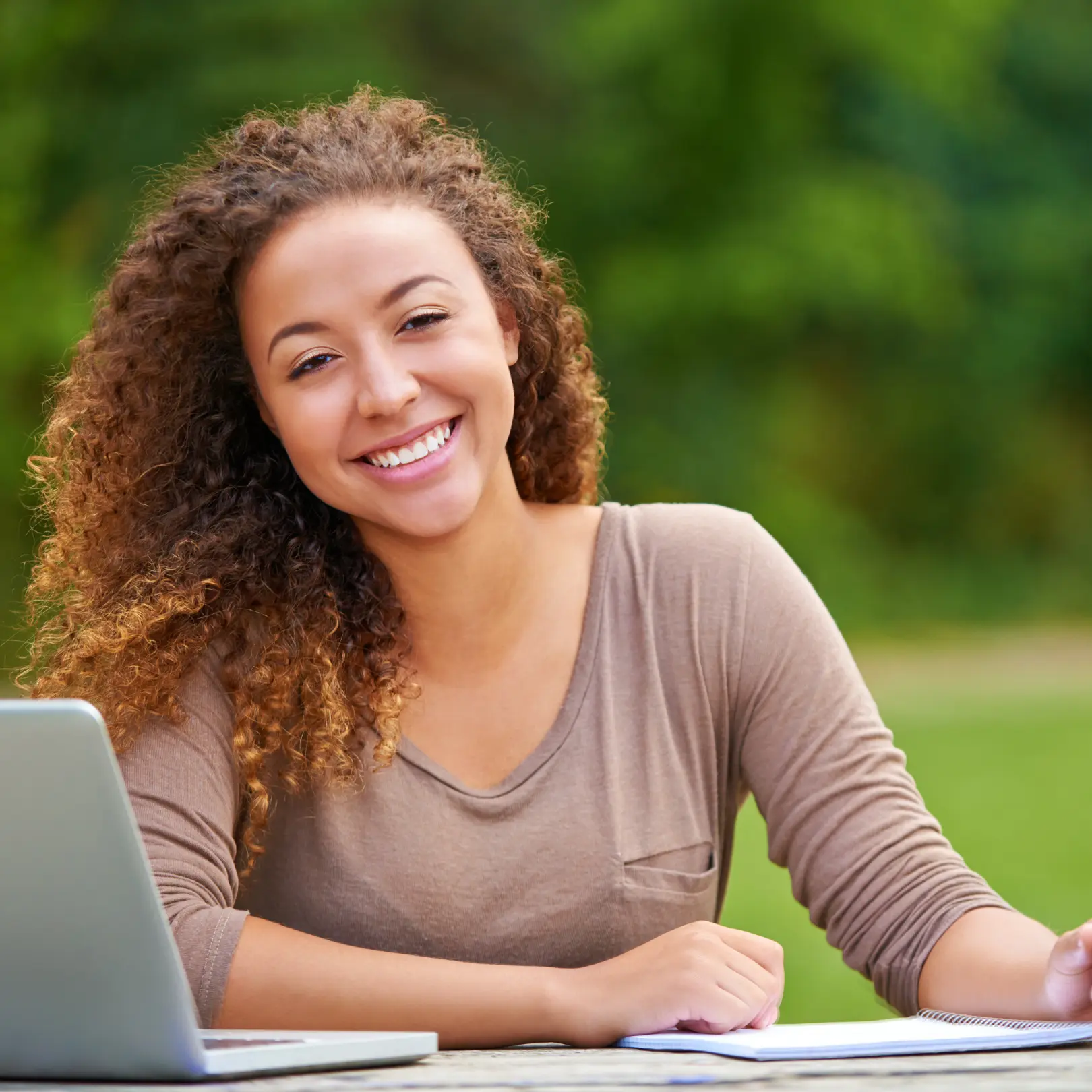 Mujer sonriendo feliz con un escritorio y una laptop