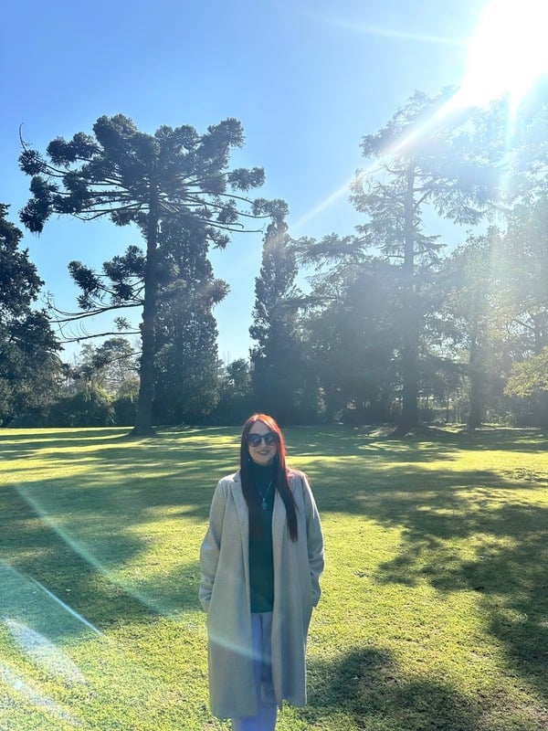 Andrea Erazo en un parque, con lentes y abrigo gris