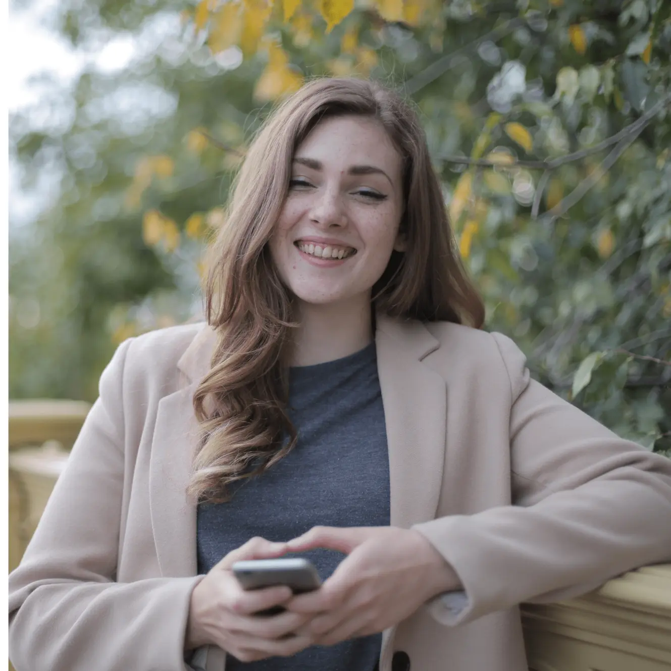 Una mujer con un saco gris feliz